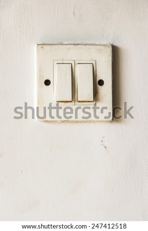 white double switch in position off on white wall