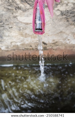 top view of faucet drop water into old basin in public place, pushkar, India