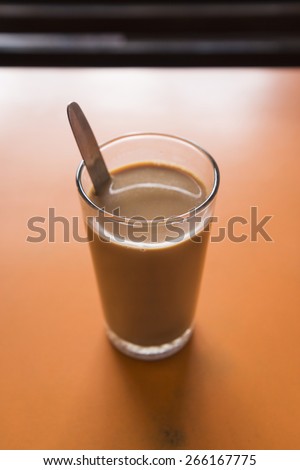 glass of india milk tea or Chai in Hindi name on orange table