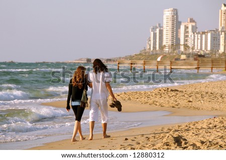 Young couple walking on a sea coast