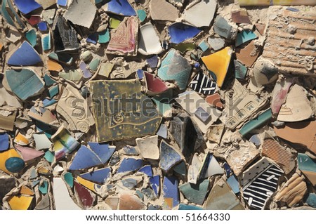 Wall faced with fragments of broken art ceramics
