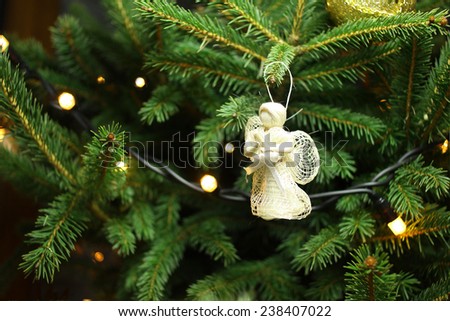 Christmas angel on christmas tree branch, lights hanging in a tree