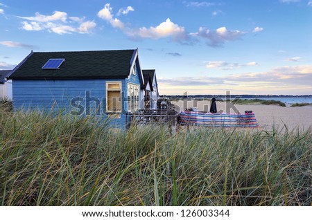 Sunset at beach huts in sand dunes at Mudeford Spit on Hengistbury Head near Bournemouth and Christchurch in Dorset.