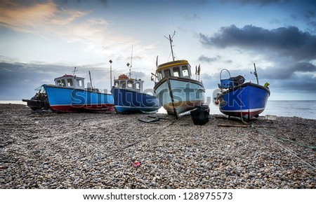 Fishing boats at sunrise on the beach at Beer on Devon\'s Jurassic Coast.