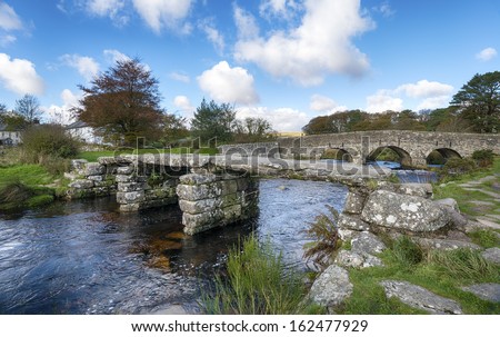 Two bridges, an ancient clapper bridge and arched bridge crossing the East Dart river at Post Bridge on Dartmoor