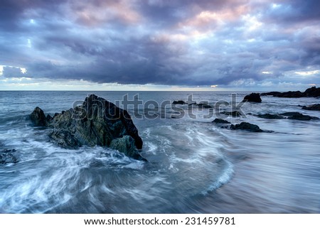 The tide flowing over rocks on the beach at Portwrinkle on the south coast of Cornwall