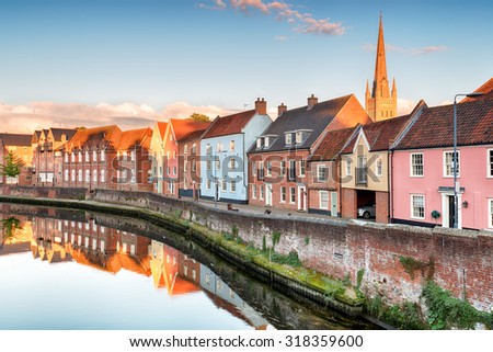Pretty town houses overlooking the river Yare at Norwich in Norfolk with the cathedral spire in the background