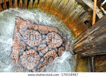 wooden tub for carpet washing under a stream of water