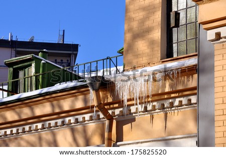 frozen icicles on the roof of the old building