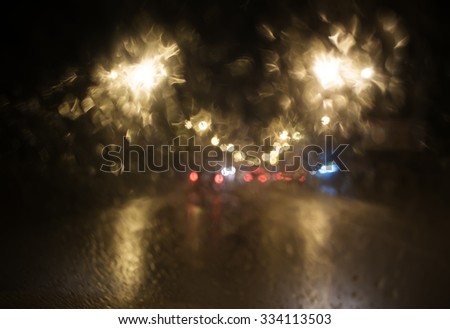 Rainy evening in the city.Selective focus.Walk to the car through the city in the rain.View through the car window.Background.