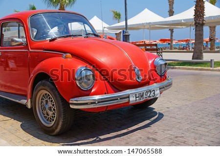 LARNACA, CYPRUS - JUL 15: Vintage red Volkswagen VW Beetle car (Volkswagen Type 1, Volkswagen Bug) parked near the Finikoudes Beach (Larnaca Promenade) on July 15, 2013 in Larnaca, Cyprus.