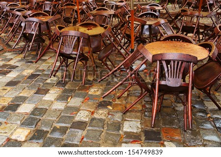 Summer has gone - empty street cafe tables under the rain (Lviv, Ukraine)