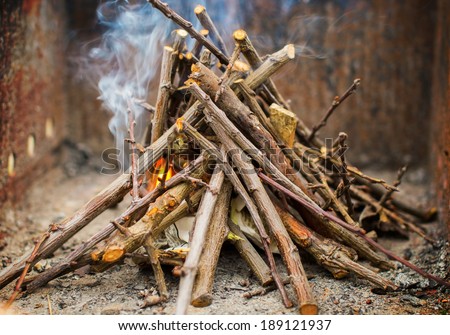 Kindling a fire with small sticks and paper