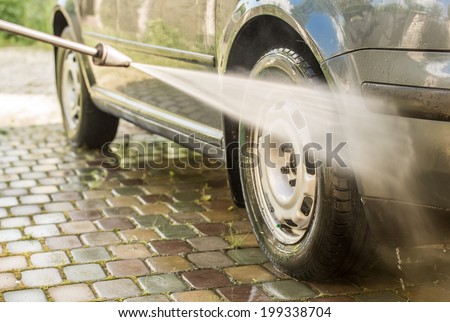 Cleaning a car with a high pressure washer