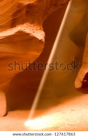 A beam of sunlight shining into Antelope Canyon, near Page, Arizona. Antelope Canyon was created by flash flood waters that eroded the canyon walls to create intricate textures and rock formations.