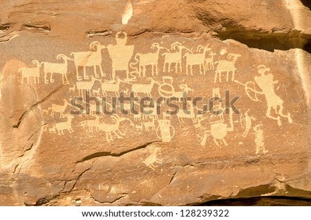 Fremont Indian hieroglyph in Nine Mile Canyon (near Price, Utah) featuring hunters with bows and arrows, a horned shamanic figure, and a shield figure in the middle of the bighorn sheep.