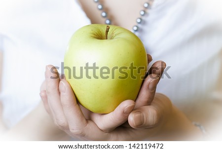 Big green apple in hands