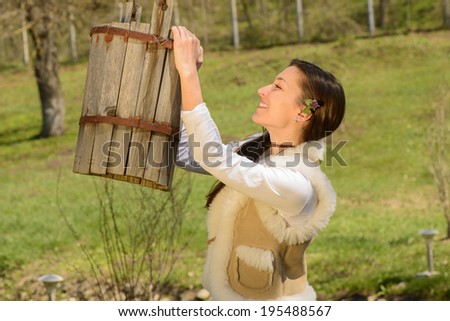 Reaching for the water: Young women reaching for a wooden rustic pile of water, smiling, on a sunny day