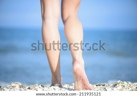 Beautiful woman legs on the beach. Women's beautiful smooth legs on the beach