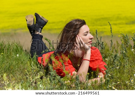 Portrait of attractive young woman smiling and laying on the grass. Field, flowers beauty, nature, - The concept of country vacation.