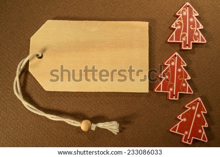 Empty tag with three Christmas decorations on brown background. Three Christmas decoration with price tag