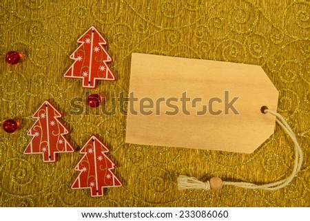 Empty tag with three Christmas decorations on golden organza background. Three Christmas decoration with price tag