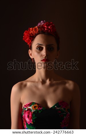 Fashion portrait of a redhead woman posing as Frida Kahlo. Attractive redhead woman. Close up portrait. Studio shot