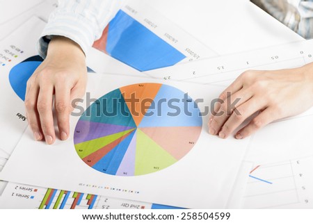 Businesswoman hands analyzing financial statistics. Business woman Meeting Planning Analysis Statistics Brainstorming Concept. Analysis of financial reports. A woman pointing at a colorful chart graph