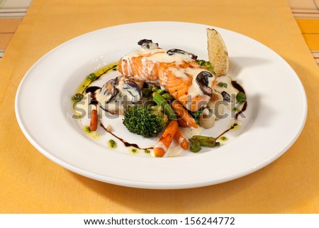 salmon grill in white sauce with vegetables, restaurant dish