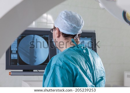 the surgeon at the monitor in the operating room