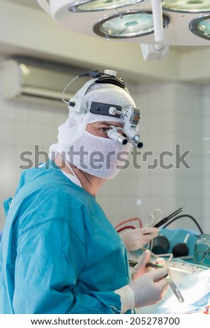 the surgeon with a magnifying glass in the operating room