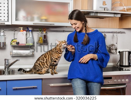 Cat and girl in the kitchen.