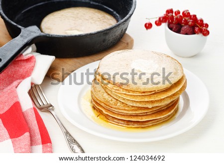 Pancakes on plate and pancake in pan on table