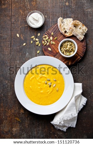 Pumpkin Soup In White Plate On Wooden Background