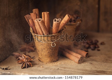 Cinnamon sticks in bucket on wooden background