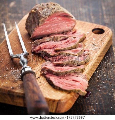 Roast Beef On Cutting Board And Meat Fork