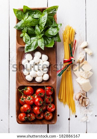 Italian flag colors with Green basil, white mozzarella, red tomatoes, parmesan and spaghetti