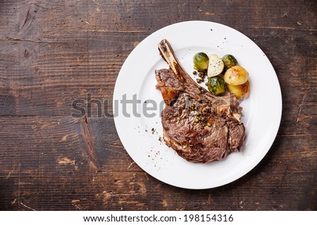 Ribeye Steak with vegetables on dark wooden background