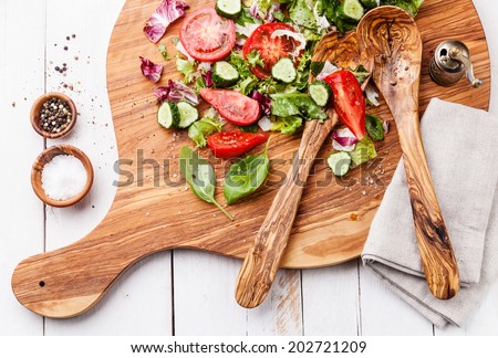 Ingredients of Fresh vegetable salad on olive wood cutting board
