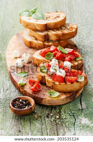 Italian bruschetta with chopped tomatoes, basil and cheese on grilled crusty bread