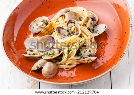 Seafood pasta with clams Spaghetti alle Vongole on orange plate