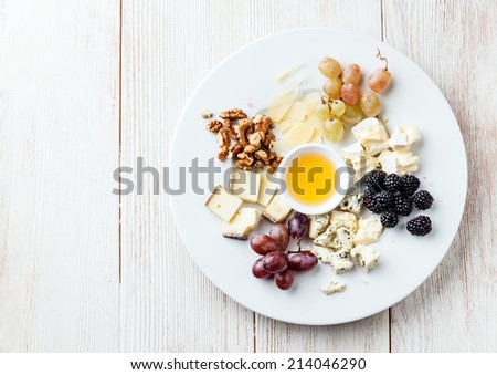 Cheese plate Assortment of various types of cheese and honey on white plate
