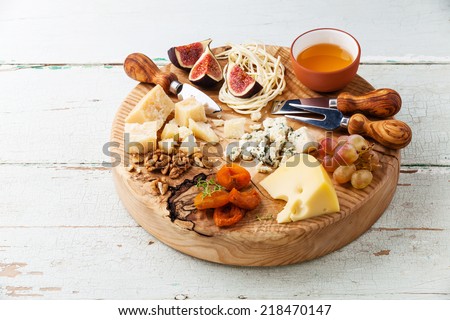 Cheese plate Assortment of various types of cheese on wooden cutting board