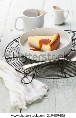 Classical Cheesecake and caramel Sauce on plate on blue texture background