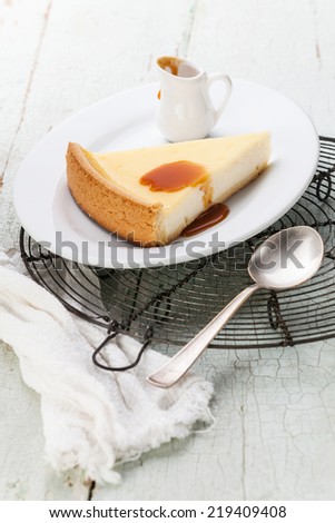 Classical Cheesecake and caramel Sauce on plate on blue texture background
