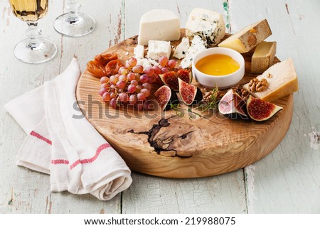 Cheese plate Assortment of various types of cheese on wooden cutting board