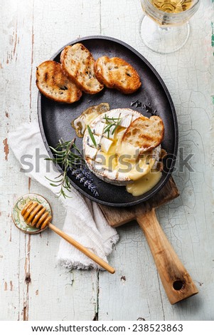 Baked Camembert cheese with toasted bread on cast-iron frying pan
