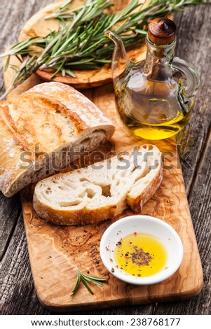 Sliced bread Ciabatta and extra virgin Olive oil on olive wood cookware background