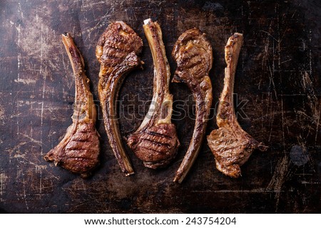 Roasted lamb ribs on dark steel background