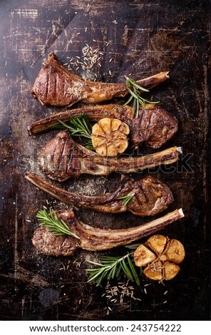 Roasted lamb ribs with spices and garlic on dark steel background